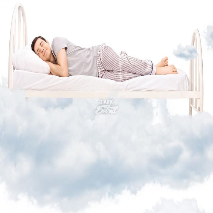 una ersona durmiendo y una cama sobre una nube